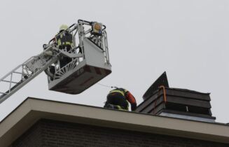 brandweer wederom gealarmeerd voor loszittende kap van schoorsteen op dak van flat, Buitendijklaan in Leiderdorp
