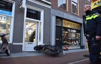 Lesmotor rijdt door winkeldeur, bestuurster raakt gewond, Haarlemmerstraat in Leiden