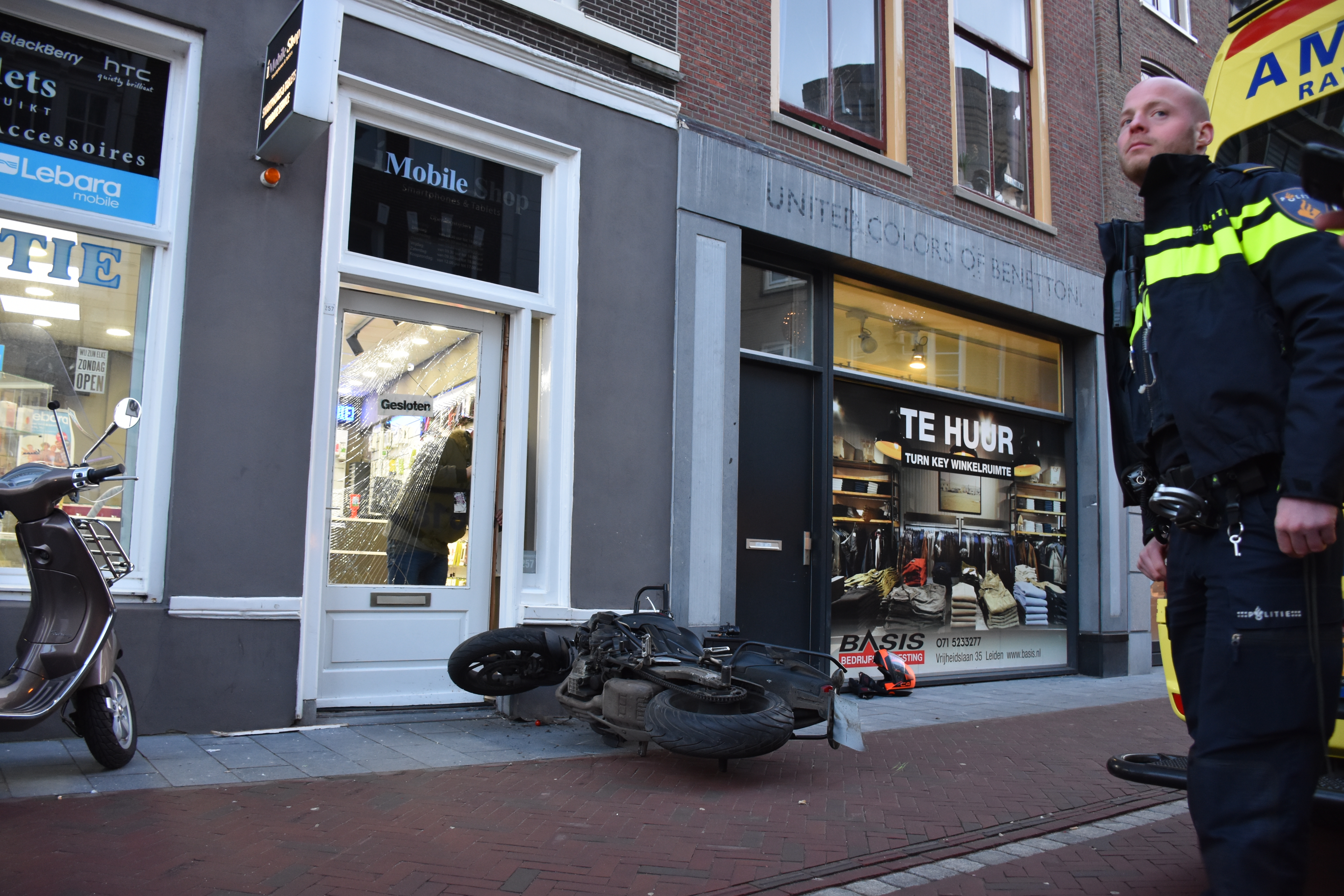Lesmotor rijdt door winkeldeur, bestuurster raakt gewond, Haarlemmerstraat in Leiden