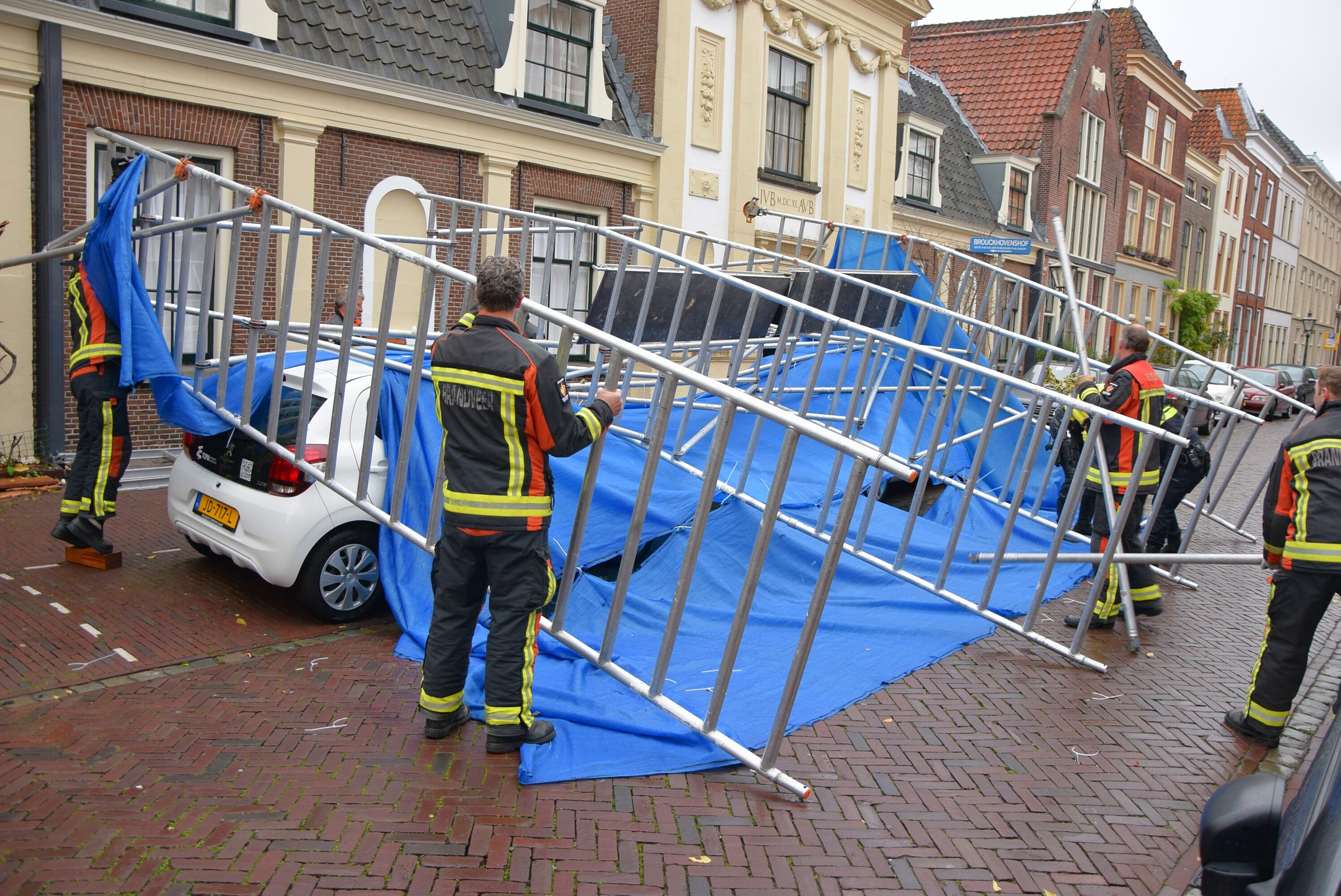 Meerdere voertuigen beschadigd na omgevallen steiger, Brouckhovenshof in Leiden