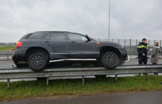 Auto belandt op vangrail na ongeval door vloeistof op de weg, N446 in Leiderdorp
