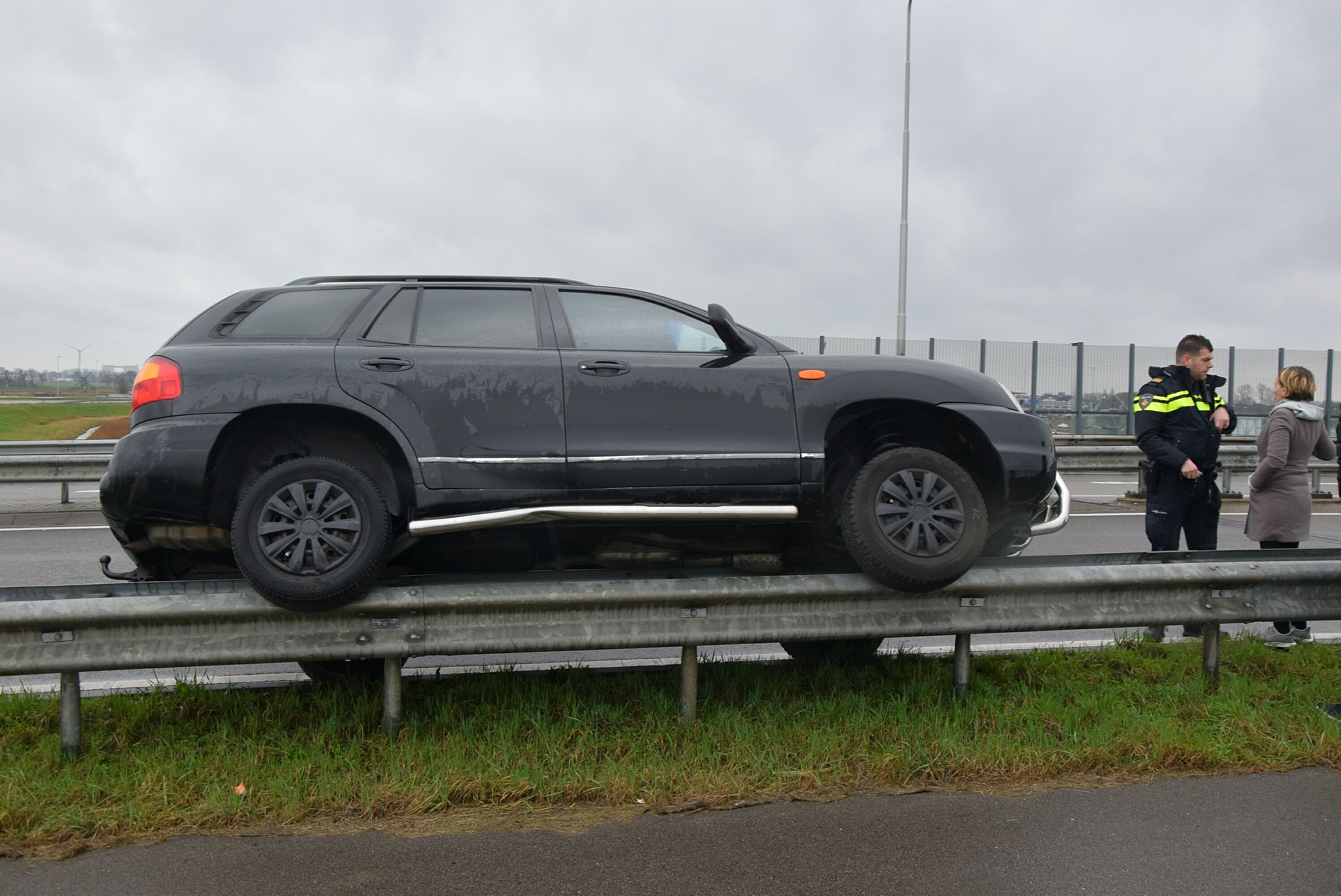 Auto belandt op vangrail na ongeval door vloeistof op de weg, N446 in Leiderdorp