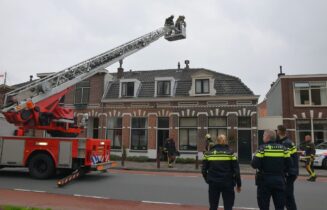 Brandweer veegt schoorsteen na brand, Zijlsingel in Leiden