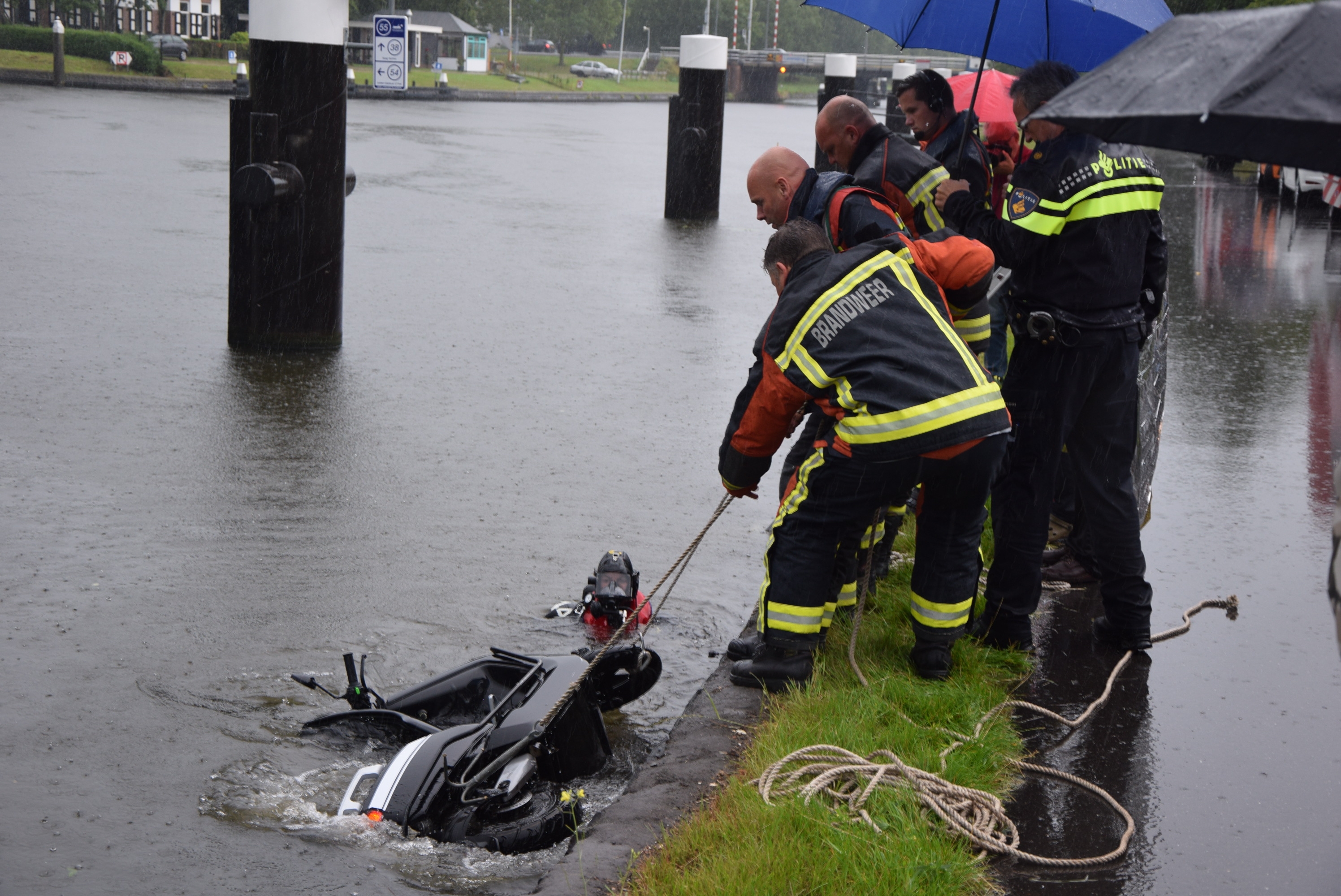 Scooterrijder belandt met scooter en al in het kanaal, Vlietweg in Leiden