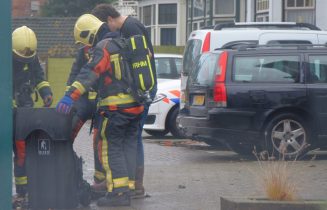 Buurtbewoners blussen brandende kliko, Geversstraat in Oegstgeest