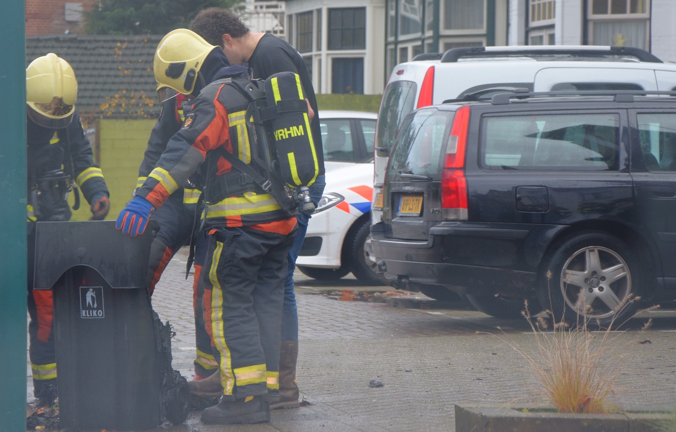 Buurtbewoners blussen brandende kliko, Geversstraat in Oegstgeest