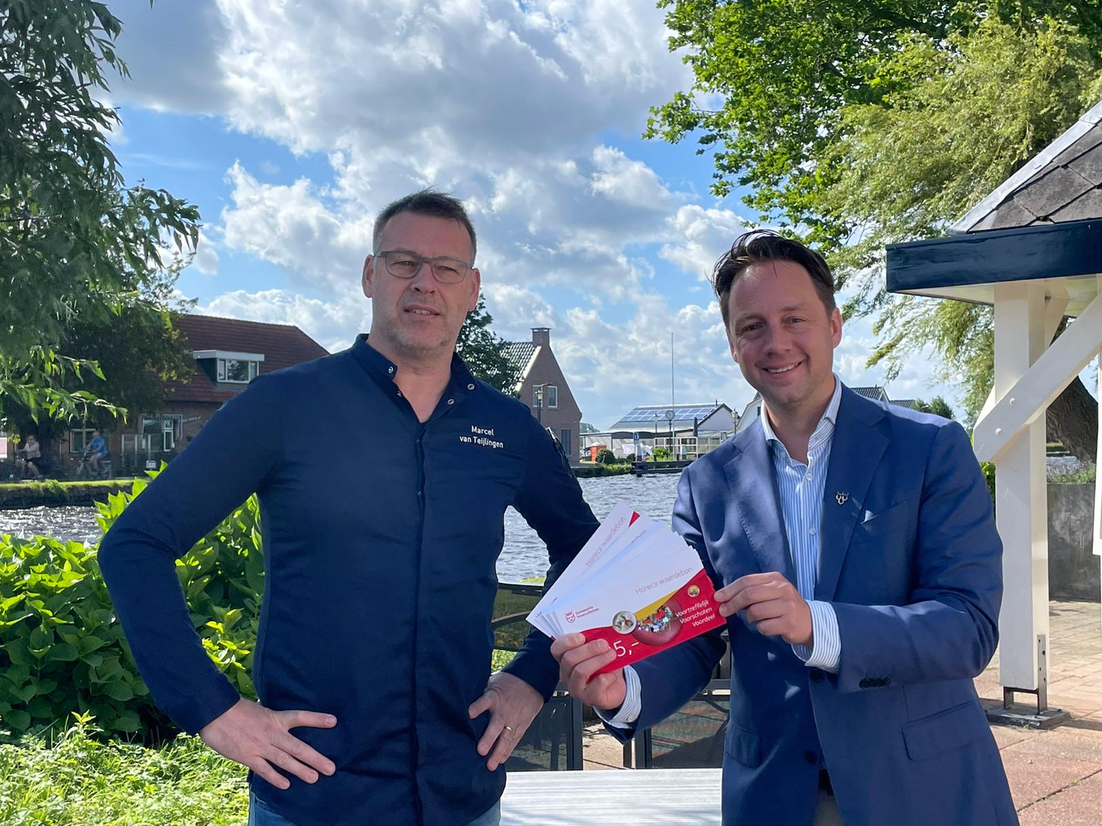 Foto overhandiging horecabonnen door wethouder De Bruijn