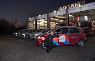 Brandweerchauffeur plakt GGD logo op dienstauto