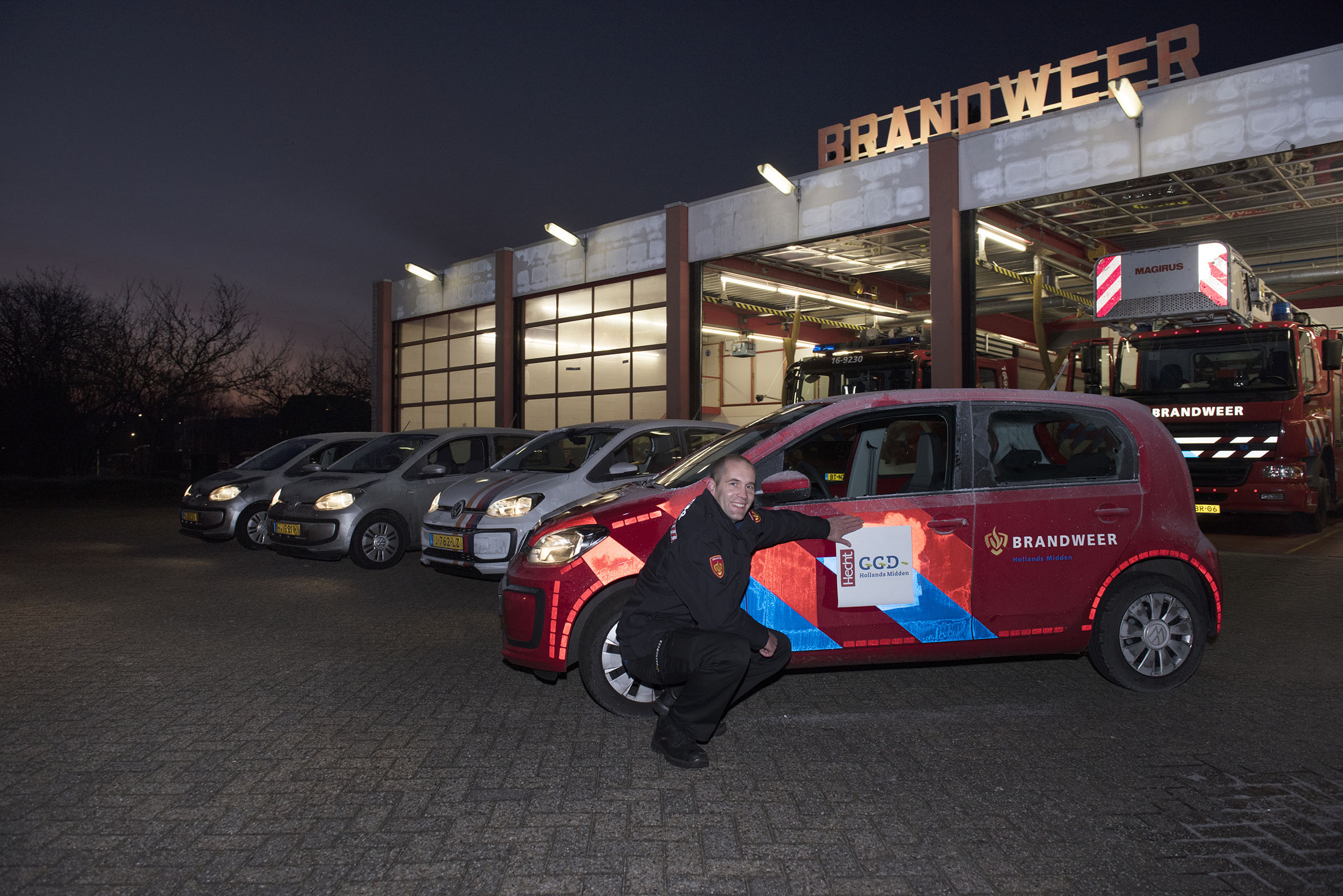 Brandweerchauffeur plakt GGD logo op dienstauto